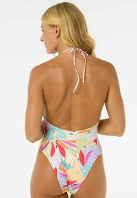Maillot de bain une pièce avec un motif de feuilles tropicales vibrantes dans des teintes de vert, rose et orange, avec un col halter et un dos ouvert.
