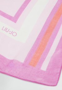 Écharpe légère avec un motif géométrique dans des teintes de rose, blanc et orange, avec un logo visible dans le coin. Fini doux et texturé.