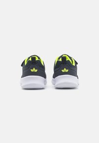 Baskets de sport en maille noires avec des accents jaune fluo, une semelle blanche rembourrée et un design de talon à double texture.