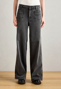 Grijze denim jeans met wijde pijpen en een hoge taille, voorzien van twee voorzakken en twee achterzakken, afgewerkt met contrasterende stikseldetails.