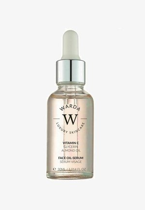 Clear glass dropper bottle containing a light amber serum. Silver cap, black text labels detailing ingredients and product information.