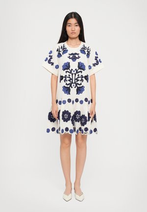 Short-sleeve white dress with dark blue floral embroidery, scalloped hem, and a relaxed fit, featuring large flower motifs and a lightweight texture.