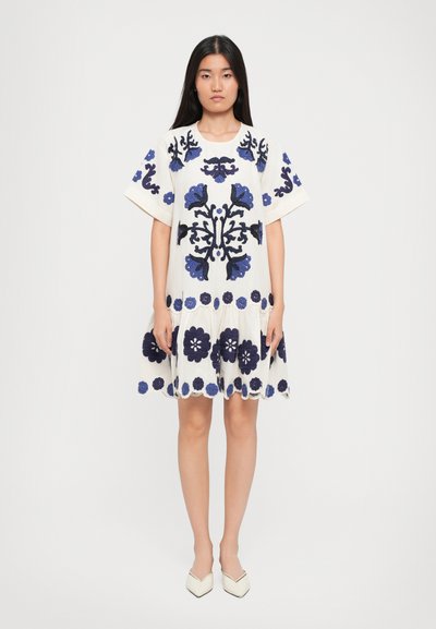 Kortsligged witte jurk met donkerblauwe bloemenborduursels, een geschulpte zoom en een ontspannen pasvorm, met grote bloemenmotieven en een lichte textuur.