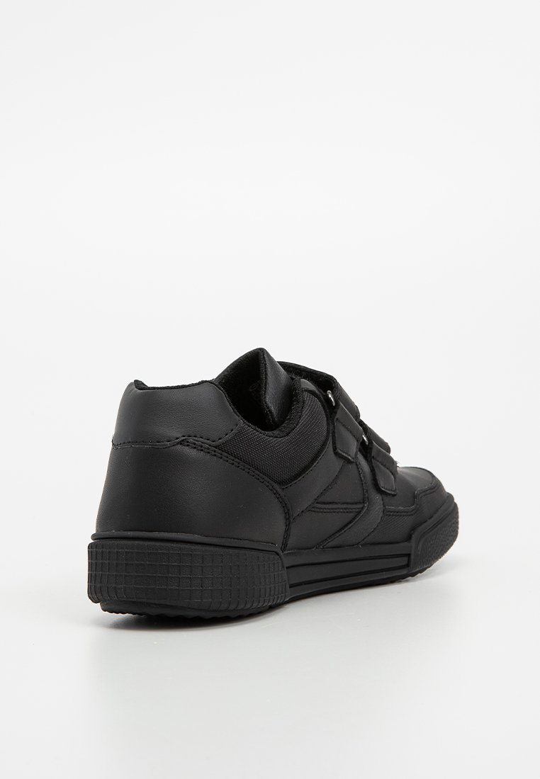 Zapatilla negra con parte superior de cuero suave, suela de goma texturizada y cierre de correa con velcro. Punta redonda y talón reforzado.