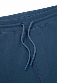Blue sweatpants with a ribbed texture, drawstring closure featuring blue tips, and reinforced stitching along the seams.