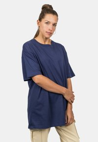 Marineblauwe katoenen t-shirt met een relaxed fit, korte mouwen en een ronde hals. De stof heeft een gladde textuur en minimale details.