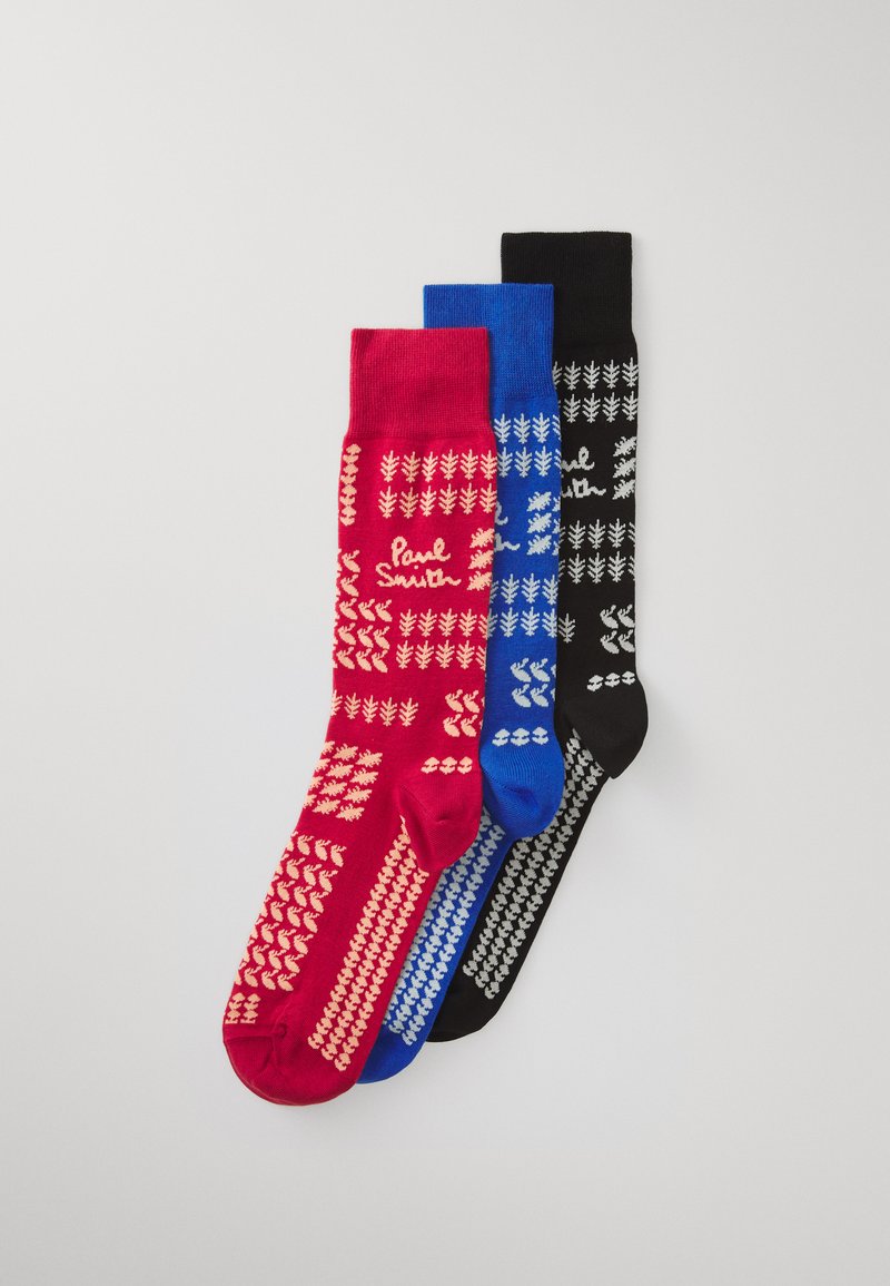 Tres pares de calcetines: rojos con patrones crema, azules con blanco y negros con gris. Cada uno presenta un logo de marca y diseños geométricos.