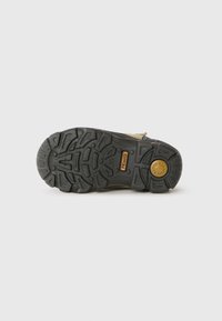 Talpa de bocanc cu profil adânc, material din cauciuc și culori contrastante. Prezintă un logo circular și numele brandului, concepută pentru tracțiune și durabilitate.