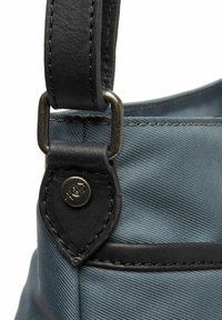 Borsa a mano in tessuto grigio con una tracolla in pelle nera, accessori in metallo e una superficie testurizzata e decorata con un dettaglio del logo.