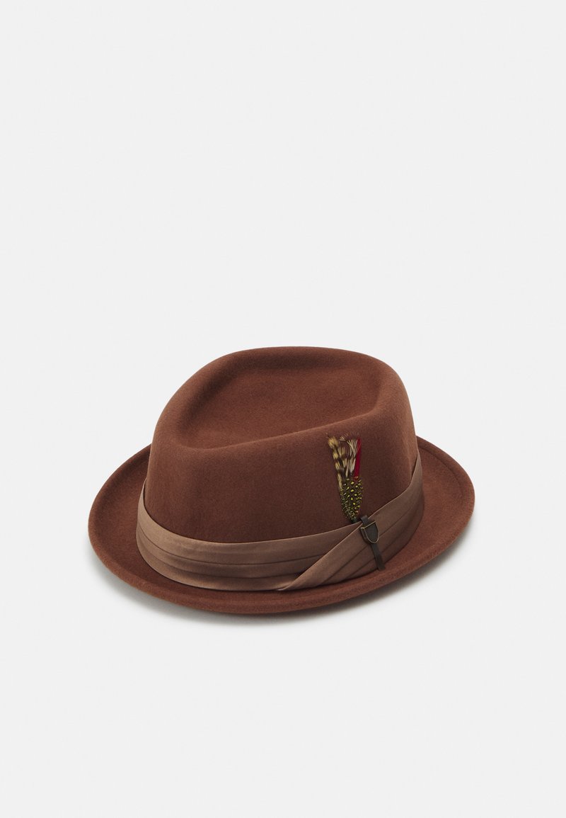 Brun filt fedora med ett brett satängband. Har en dekorativ fjäderdetalj och en böjd skärm, vilket ger en klassisk design.