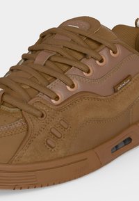 Καφέ σουέτ και διχτυωτό sneaker με δερμάτινες λεπτομέρειες, καφέ κορδόνια και ορατή υπερυψωμένη σόλα αέρα με τη μάρκα "globe" στο πλάι.