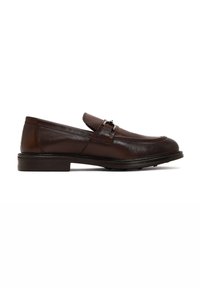 Brown leather loafers with a smooth texture, rounded toe, decorative strap with buckle, and flat rubber sole. Side view.