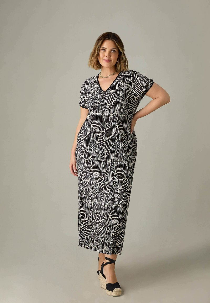 Maxiklänning i svart och vitt bladmönster; korta ärmar, V-ringning, lös passform, lättviktsmaterial; kombinerad med svarta espadriller i kilklack.