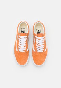 Baskets en daim orange avec lacets et accents blancs. Bout arrondi, semelle en caoutchouc plate et logo prominent sur la semelle intérieure. Design classique bas.