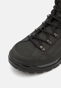 Dunkelgrüner Wanderschuh mit einem strukturierten Wildleder-Obermaterial, ausgestattet mit schwarzen Schnürsenkeln, metallischen Ösen und einer robusten Gummisohle.