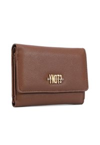 Portafoglio in pelle marrone con texture, chiusura a flap e logo metallico dorato "YNOT?" con un dettaglio a freccia al centro frontale.