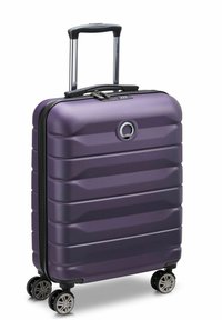 Maleta rígida de color púrpura con un diseño acanalado, cremallera negra, asa telescópica y cuatro ruedas giratorias para una fácil movilidad.