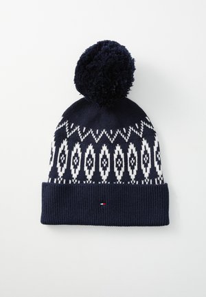Bonnet en tricot bleu marine avec un motif géométrique blanc, doté d'un revers côtelé texturé et d'un pompon duveteux sur le dessus. Détail de petit logo inclus.