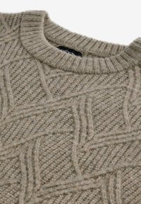 Beżowy sweter dzianinowy z teksturowanym wzorem w romby, ryfle na dekolcie oraz miękkiego, wełnianego materiału. Posiada widoczne szwy.