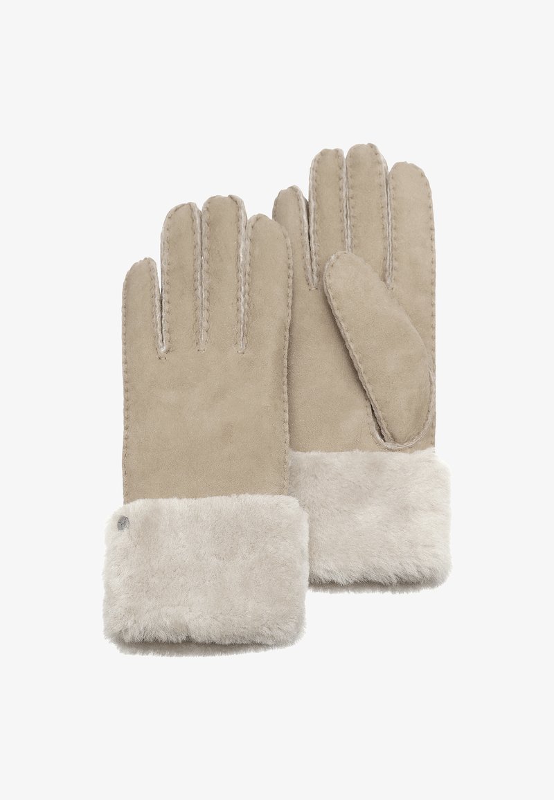 Béžové rukavice vyrobené z semiše s měkkým kožíškovým manžetou. Mezi jejich vlastnosti patří šité švy a záplata na palci, které zajišťují teplo a pohodlí.