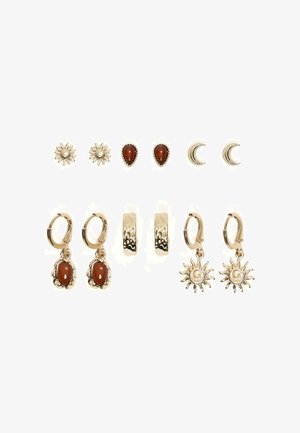 Seks par ørestikker og øreringe i guldfarvet metal med motiver som sol, dråbe, halvmåne og teksturerede guldfarvede hoops på en hvid baggrund.
