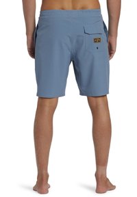 Blauwe zwembroek met een elastische tailleband, achterzak en logopatch. De stof lijkt glad en lichtgewicht, geschikt voor wateractiviteiten.