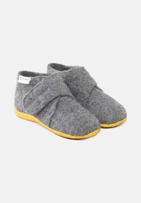 Pantofole grigie in feltro con un design a strap incrociato, dotate di una suola in gomma gialla e un piccolo etichetta sul lato.