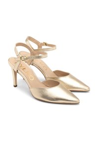 Sandalele cu toc slingback din metal auriu au vârful ascuțit, curele subțiri pentru gleznă și un toc subțire de 10 cm. Textură netedă cu un luciu subtil.