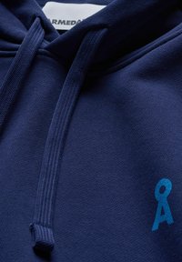 Marineblauwe hoodie van een katoenmengsel, met een gestructureerde stof, een capuchon met trekkoord en een klein blauw logo aan de voorkant.