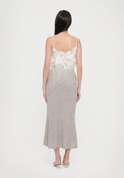 Luftige Bluse mit floralem Muster, verstellbaren Trägern und schichtdesign; metallische, strukturierte Midikleid mit schimmernden Akzenten.