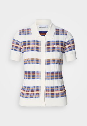 Polo a maniche corte color crema, caratterizzato da un motivo a quadri con righe blu, rosse e marroni, e una chiusura a bottoni con colletto.