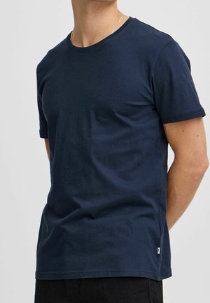 T-shirt en coton bleu marine avec un col rond et des manches courtes. Présente une petite étiquette logo sur le côté gauche près de l'ourlet.