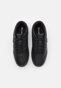 Svarta sneakers med en slät syntetisk ovandel, platta skosnören, vadderad krage och texturerade detaljer. Har en logotyp på tungan och sidan.