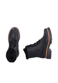 Bottes en cuir noir avec un col en fourrure, fermeture lacée à l'avant, œillets renforcés et semelle en caoutchouc avec un motif de traction texturé.