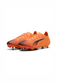Scarpini da calcio arancioni con una parte superiore testurizzata, design degradé nero, chiusura con lacci e tacchetti sagomati per trazione.