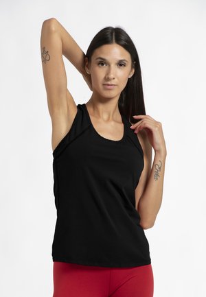 Black tank top with a round neckline, made of soft material, paired with red leggings. Features stitched seams and a relaxed fit.