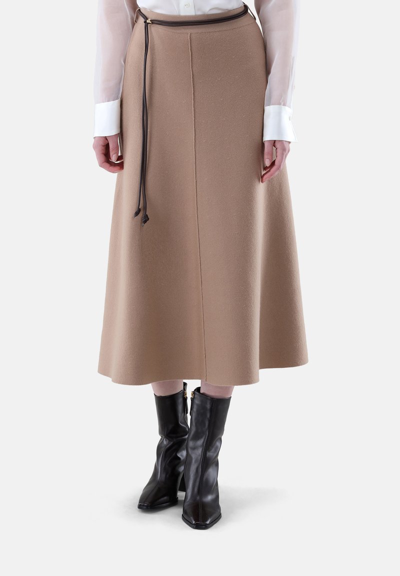 Beige Midi-Rock aus weichem Stoff, mit geradem Schnitt, Gummizug in der Taille und kombiniert mit schwarzen Ankle Boots.
