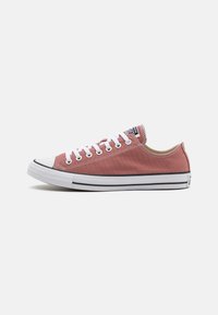Zapatillas de lona en color rosa empolvado con puntera y suela de goma blanca. Presenta cordones y costuras blancas, con el logo en la lengüeta.
