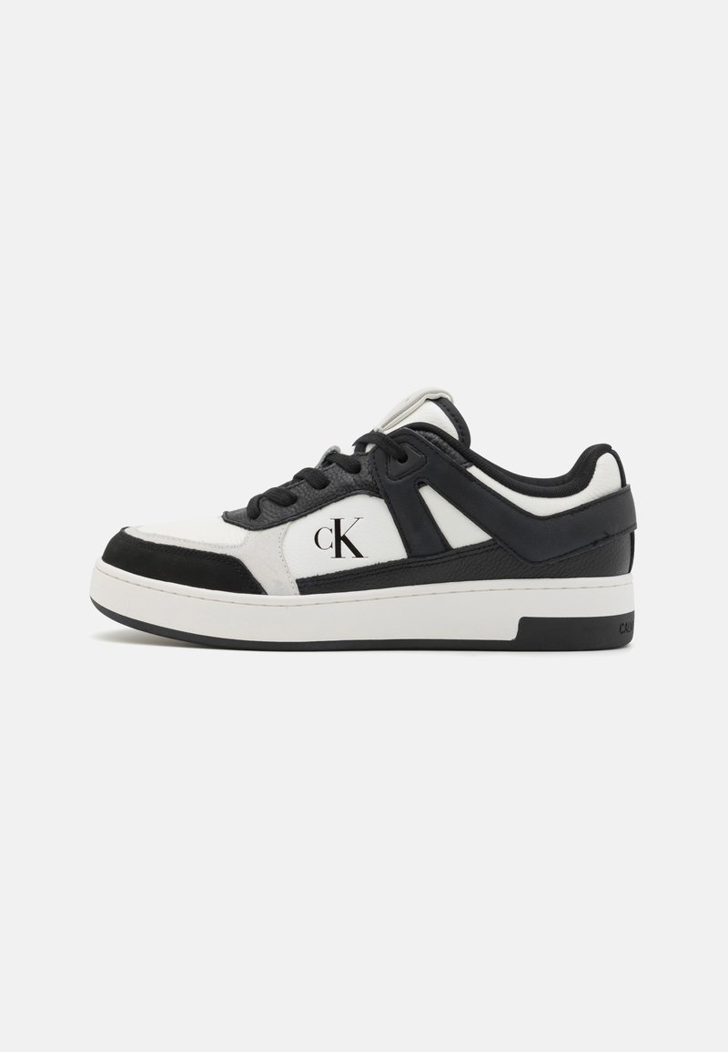 Sapatilha em preto e branco com uma mistura de couro e camurça. Apresenta um design de atacador, sola acolchoada e um discreto logotipo 'CK' na lateral.