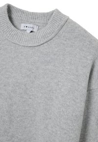 Hellgrauer Strickpullover mit geripptem Rundhalsausschnitt. Weiche Textur, mittlere Dicke, mit einem Etikett auf der Innenseite des Kragens.