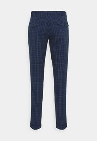 Námořnické modré kostkované kalhoty s úzkým střihem. Obsahují čtyři kapsy a poutka na opasek; látka má hladkou texturu a jemný lesk.