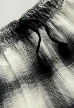 Pantalones cortos de cuadros en tonos gris y blanco con un tejido texturizado, que cuentan con una cinturilla elástica y un detalle de cordón negro.