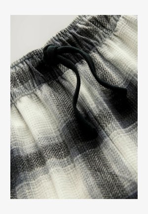 Grijze en witte geruite shorts van een textuurstof, met een elastische tailleband en een zwart trekkoorddetail.