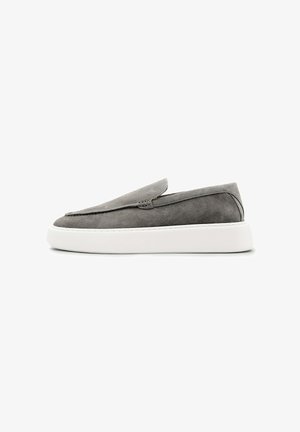Grijze suède instapsneaker met dikke witte rubberen zool, laag profiel en minimalistisch ontwerp, zijaanzicht op witte achtergrond.