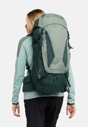 Zaino verde con un design texturizzato, spallacci regolabili e diversi scomparti. Presenta dettagli con zip e una cintura in vita imbottita.