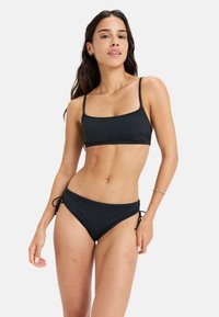 Čierny bikiny set s topom s štvorcovým výstrihom a nastaviteľnými spodniami na viazanie po bokoch. Vyrobené z hladkej tkaniny. Minimalistický dizajn bez vzorov.