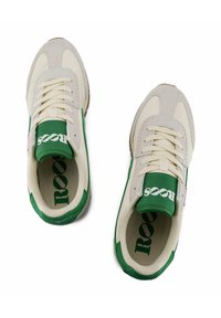 Sneakers beige in suede e mesh con dettagli verdi, caratterizzati da un logo bianco sulla linguetta e una suola in gomma naturale. Design classico con lacci.