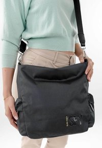 Borsa a spalla nera in rete con tracolla regolabile, hardware in argento, ampio scomparto principale e logo del marchio in oro sul fronte.