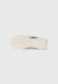 Hell-beige Sport Schuhsohle mit strukturierten Mustern und gewellten Linien, die tiefe Rillen für Traktion und Stabilität aufweist.