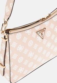 Sac en cuir synthétique rose avec un design de logo à motifs blancs, quincaillerie dorée et fermeture éclair. Comprend une sangle détachable.